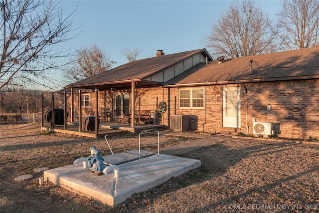 rear view of house featuring ac unit and a deck