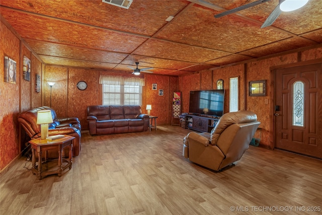 living room featuring ceiling fan, wood walls, wood ceiling, and light hardwood / wood-style flooring