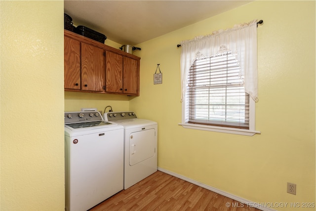 laundry room featuring cabinets, separate washer and dryer, and light wood-type flooring