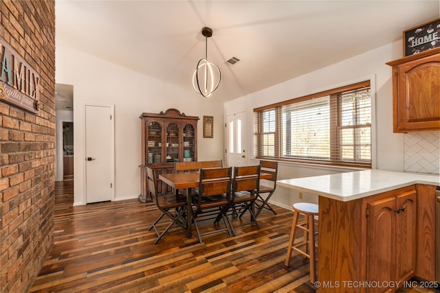 dining space with dark hardwood / wood-style flooring and lofted ceiling