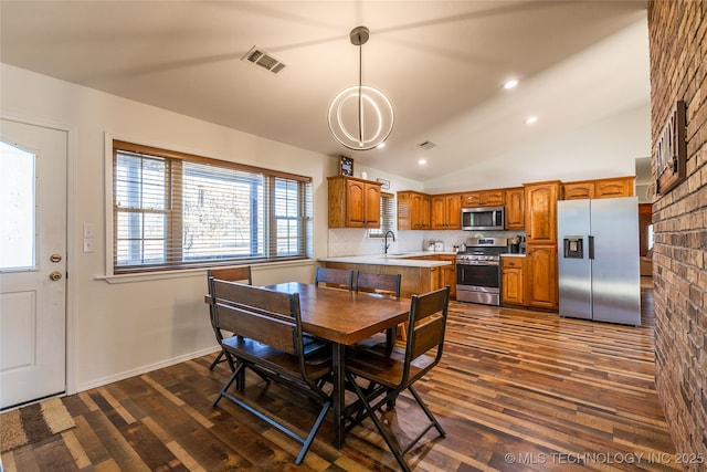 dining area featuring a chandelier, sink, dark hardwood / wood-style floors, and lofted ceiling