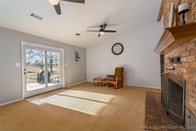 unfurnished room with carpet flooring, a brick fireplace, vaulted ceiling, and ceiling fan