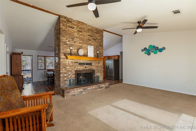 carpeted living room featuring ceiling fan, lofted ceiling, and a brick fireplace