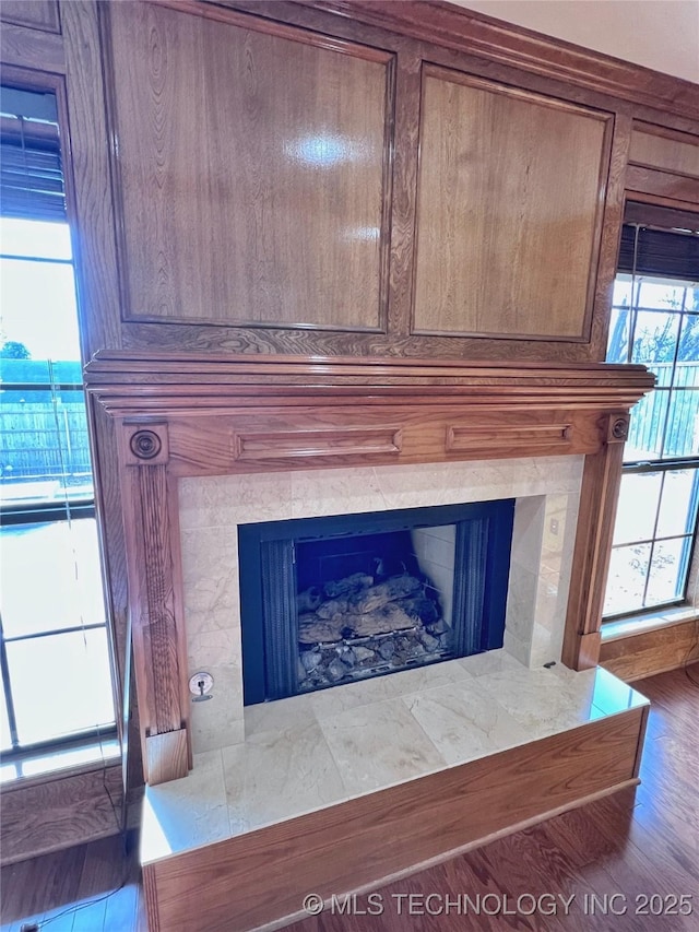 details with a tile fireplace and hardwood / wood-style flooring