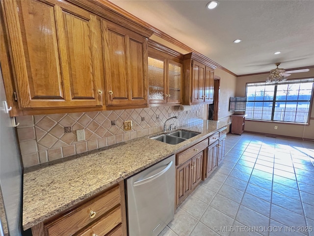 kitchen featuring light stone countertops, ceiling fan, sink, light tile patterned floors, and dishwasher