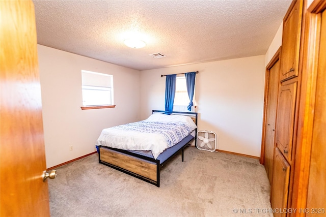 bedroom with light carpet and a textured ceiling