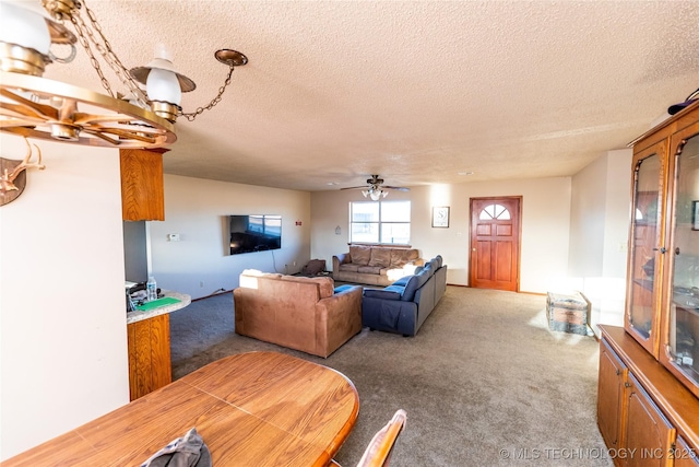 carpeted living room with a textured ceiling and ceiling fan