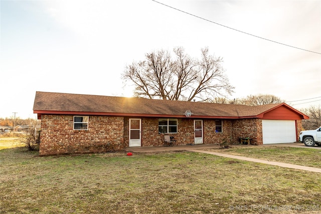 ranch-style house featuring a garage and a front lawn