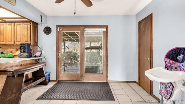 doorway to outside with ceiling fan and light tile patterned floors