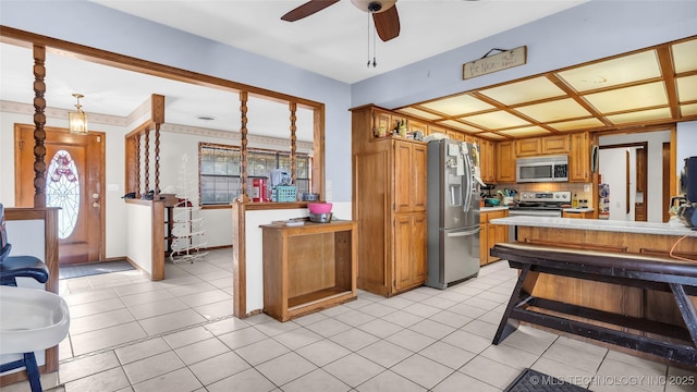 kitchen featuring backsplash, ceiling fan, light tile patterned flooring, and stainless steel appliances