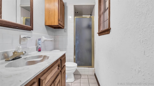 bathroom featuring tile patterned floors, toilet, vanity, and walk in shower