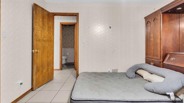 bedroom featuring light tile patterned floors and ensuite bathroom