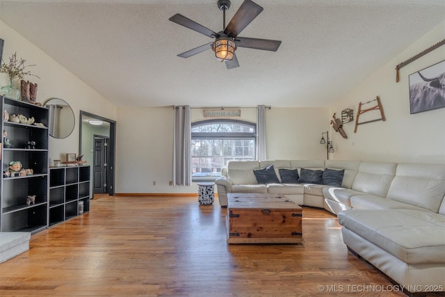 living room with ceiling fan, wood-type flooring, and a textured ceiling