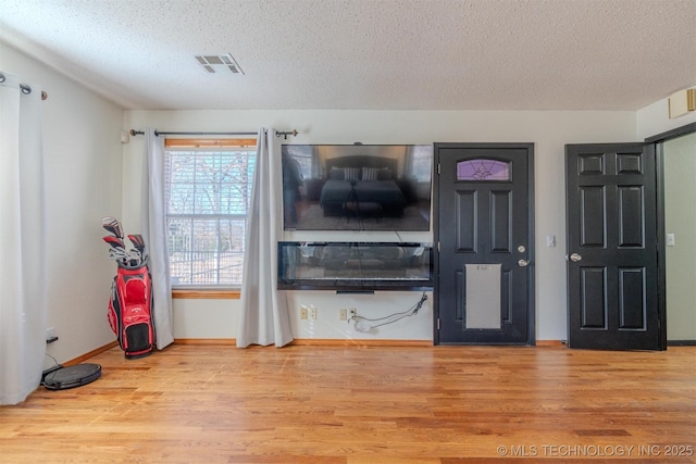 living room with light hardwood / wood-style floors and a textured ceiling