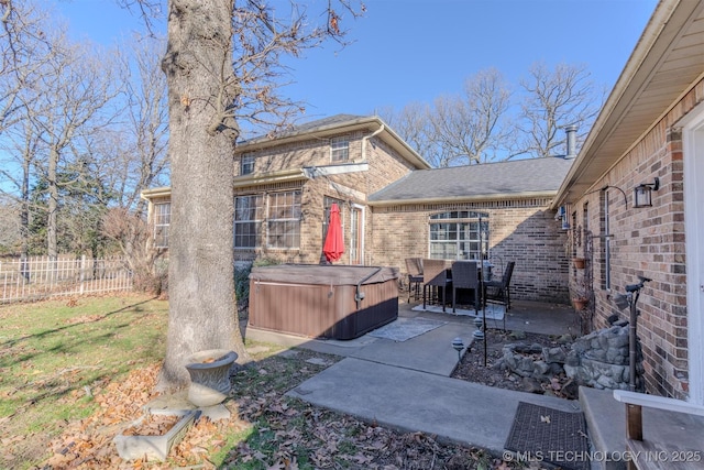 back of house with a yard, a hot tub, and a patio area