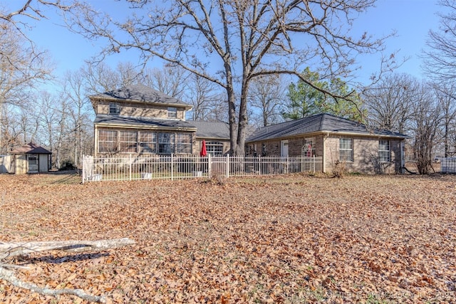 back of property with a storage shed