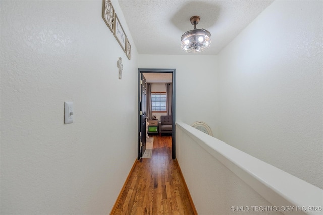 hallway featuring dark hardwood / wood-style floors and a textured ceiling