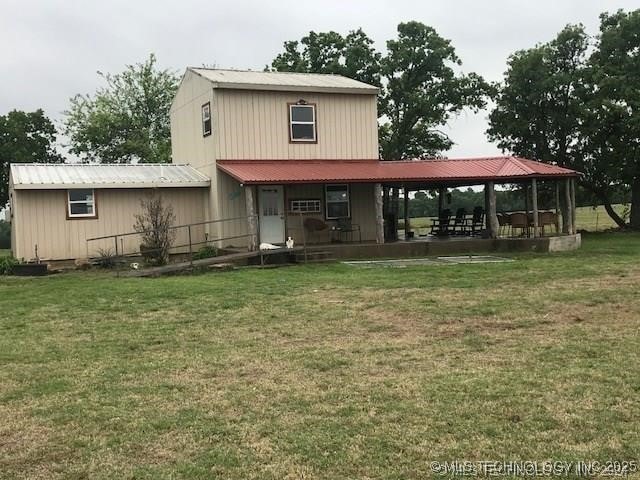 rear view of property featuring a lawn and a gazebo