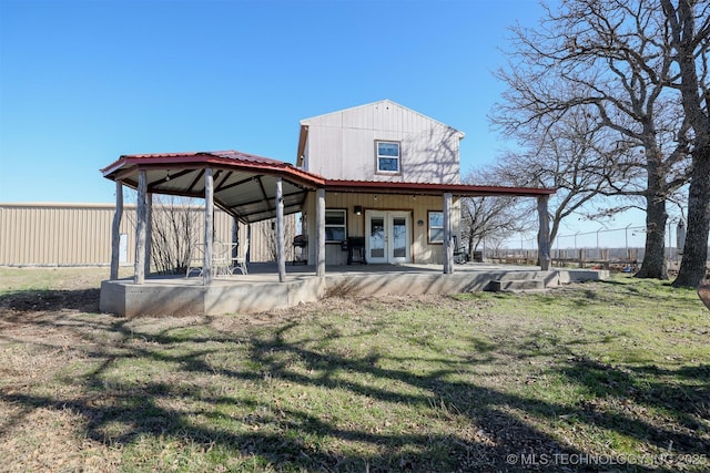 rear view of property featuring a yard, french doors, and a patio