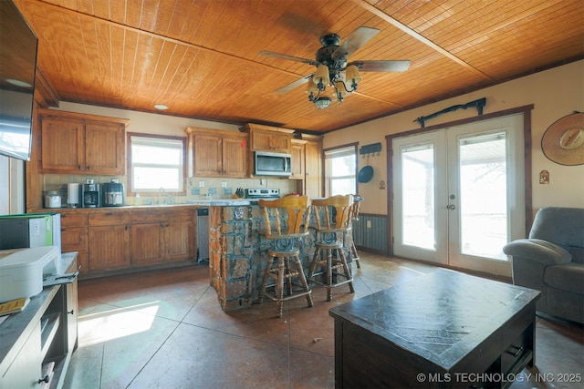 kitchen featuring a center island, a wealth of natural light, wooden ceiling, a kitchen breakfast bar, and french doors