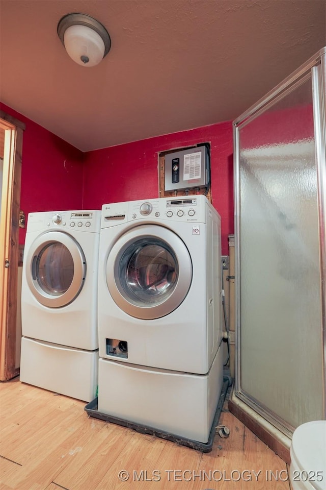 clothes washing area with hardwood / wood-style floors and independent washer and dryer