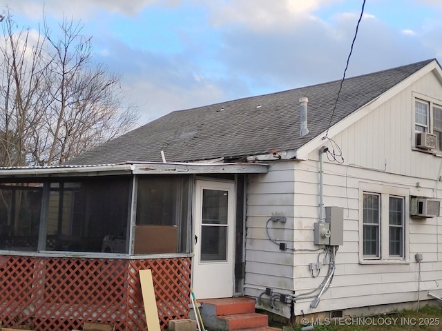 rear view of house with a sunroom, cooling unit, and a wall mounted AC