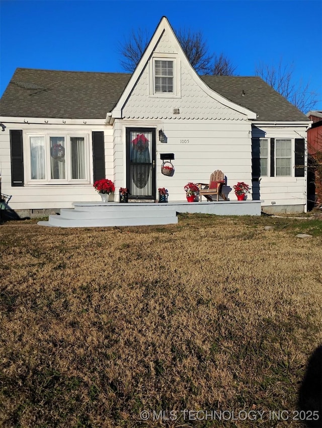 rear view of property featuring a yard