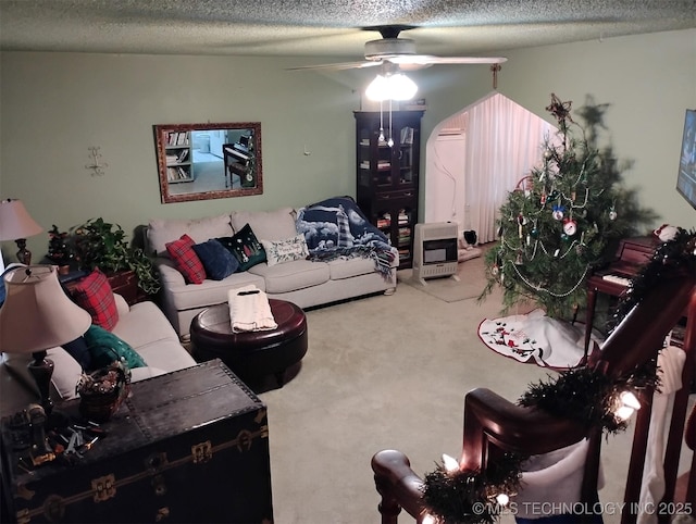 carpeted living room with ceiling fan, a textured ceiling, and heating unit