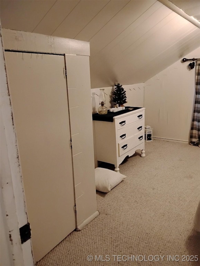 interior space featuring light carpet and vaulted ceiling