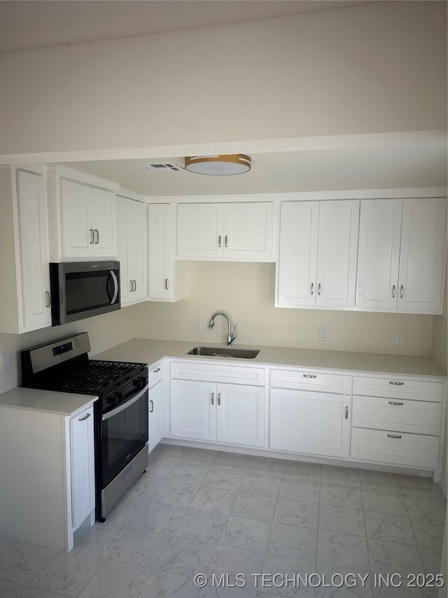 kitchen with white cabinetry, sink, and stainless steel appliances