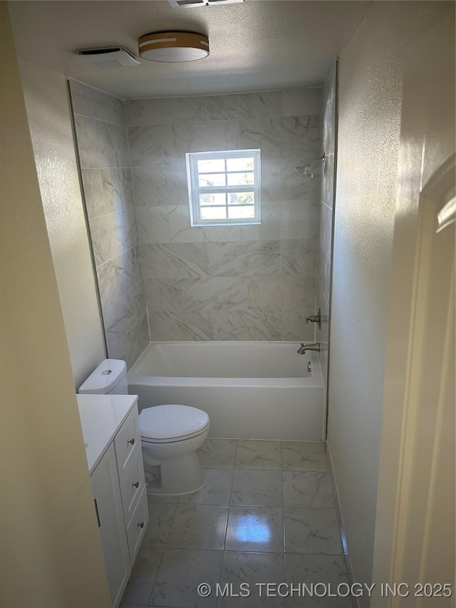 full bathroom featuring vanity, toilet, a textured ceiling, and tiled shower / bath combo