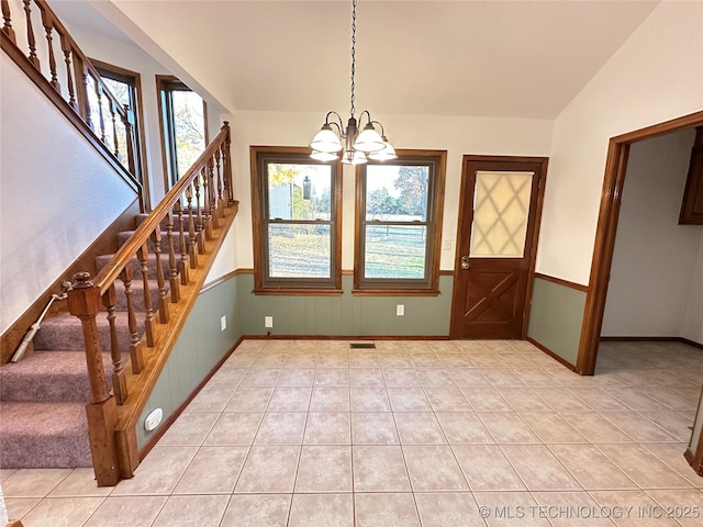 unfurnished dining area with light tile patterned flooring, lofted ceiling, and a chandelier