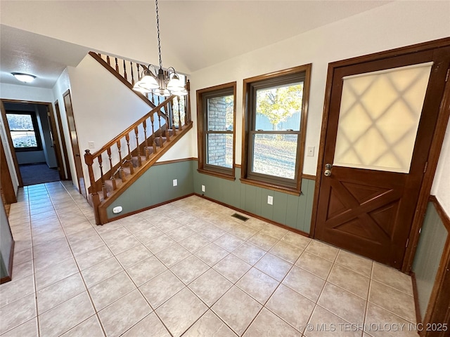 tiled foyer with a chandelier and lofted ceiling