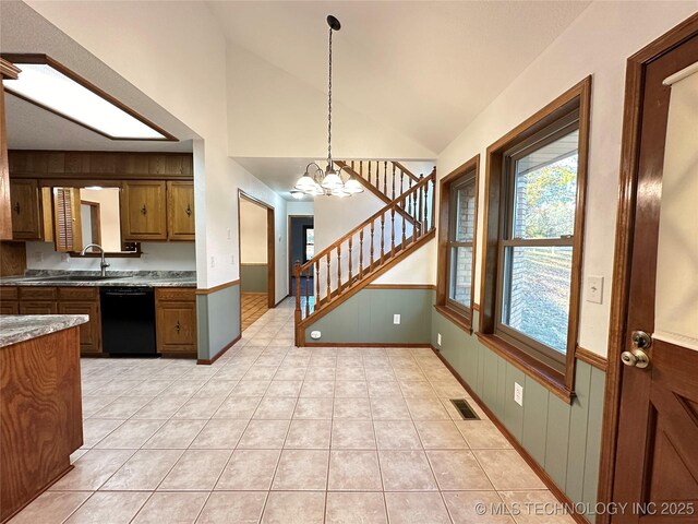 kitchen featuring dishwasher, sink, light tile patterned floors, decorative light fixtures, and a chandelier