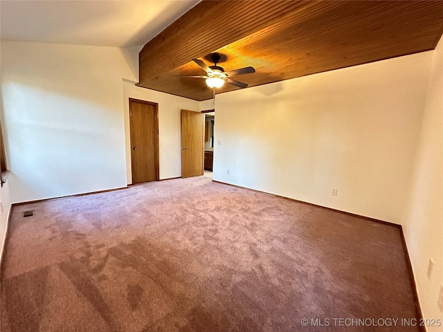 carpeted spare room with ceiling fan and wooden ceiling