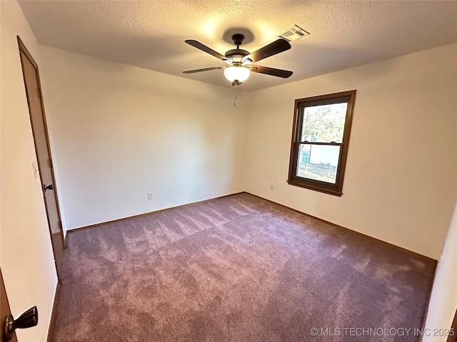 carpeted empty room with ceiling fan and a textured ceiling