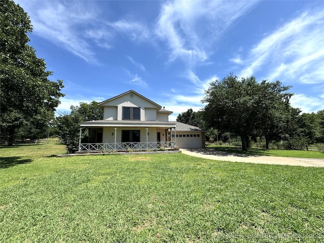 view of front of property with covered porch, a garage, and a front yard