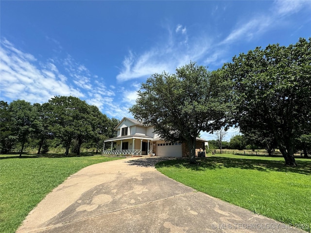 view of front of property with a porch, a garage, and a front lawn