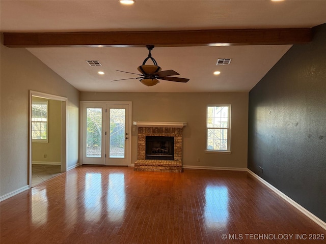 unfurnished living room featuring a brick fireplace, ceiling fan, lofted ceiling with beams, and wood-type flooring