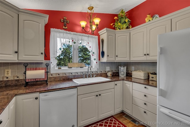 kitchen with white cabinetry, white appliances, sink, and hanging light fixtures