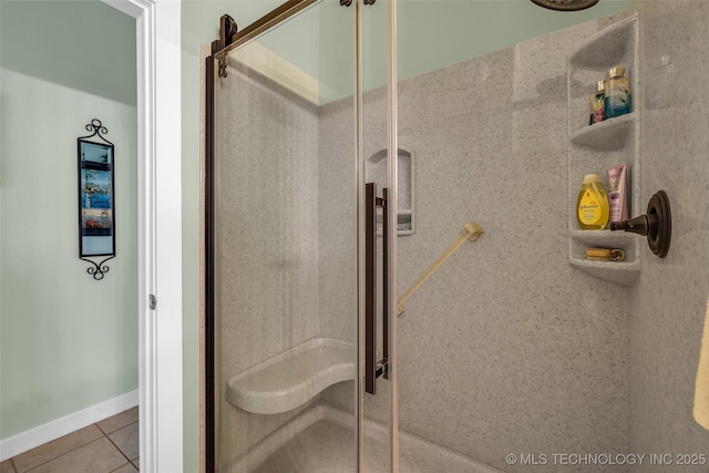 bathroom with tile patterned floors and a shower with door