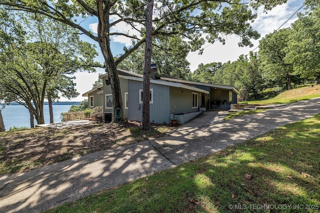 view of home's exterior featuring a lawn and a water view