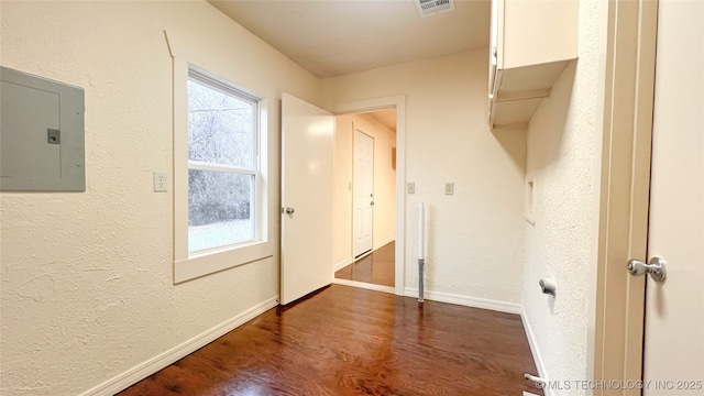 laundry room with dark hardwood / wood-style flooring, electric panel, and plenty of natural light