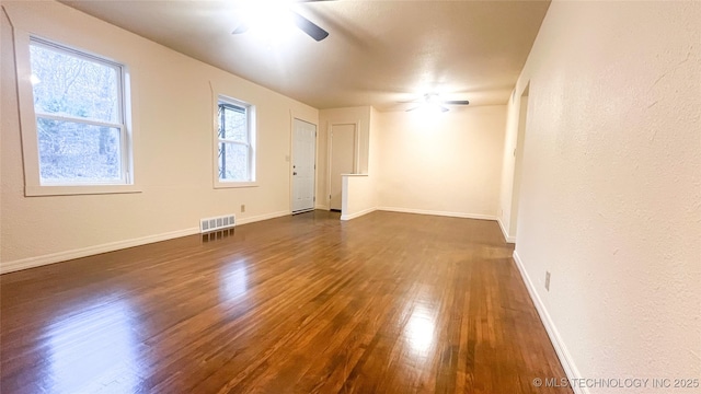 empty room with dark hardwood / wood-style flooring and ceiling fan