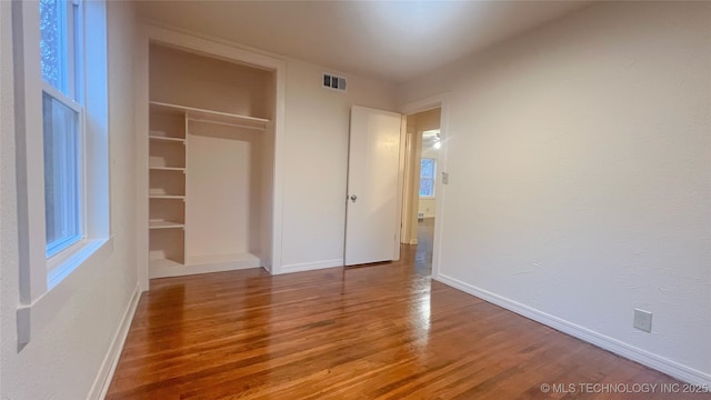 unfurnished bedroom featuring wood-type flooring and a closet