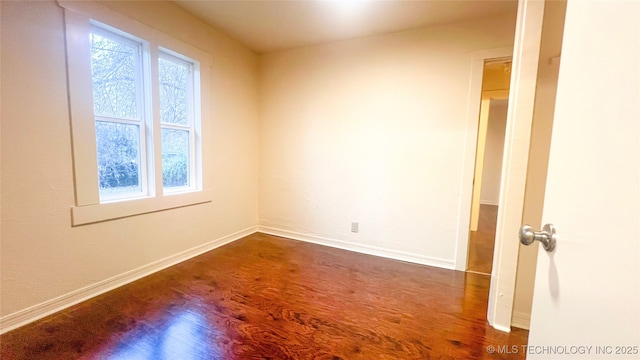 unfurnished room with dark hardwood / wood-style flooring