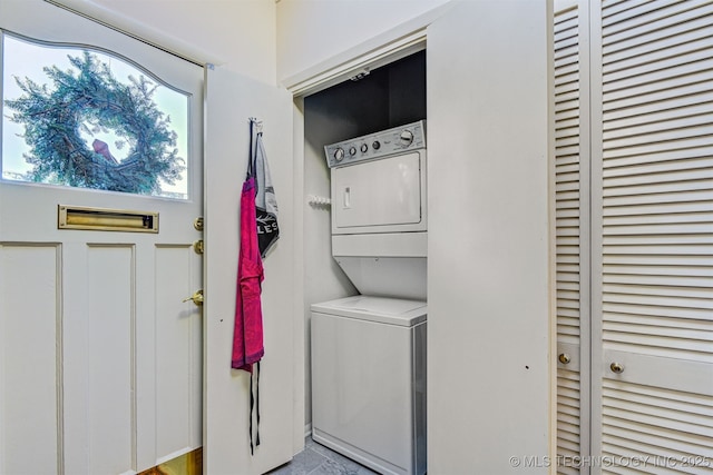 clothes washing area with stacked washer / dryer