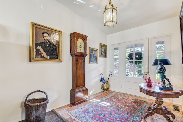 entrance foyer with tile patterned flooring and lofted ceiling