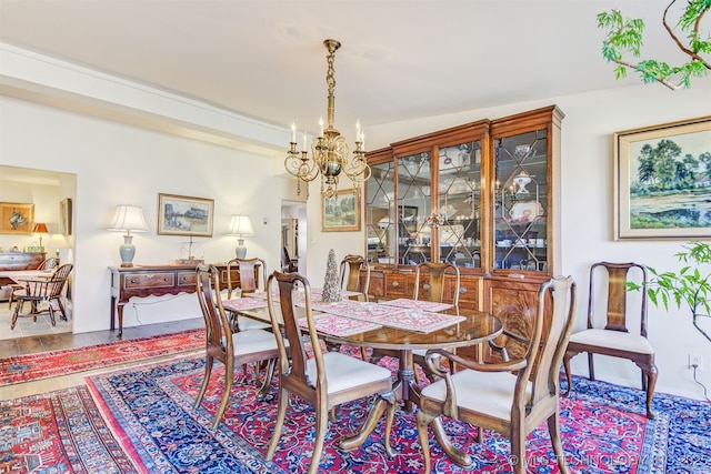 dining area with vaulted ceiling and a notable chandelier