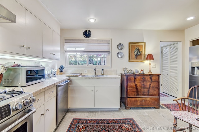 kitchen with sink, white cabinets, and appliances with stainless steel finishes